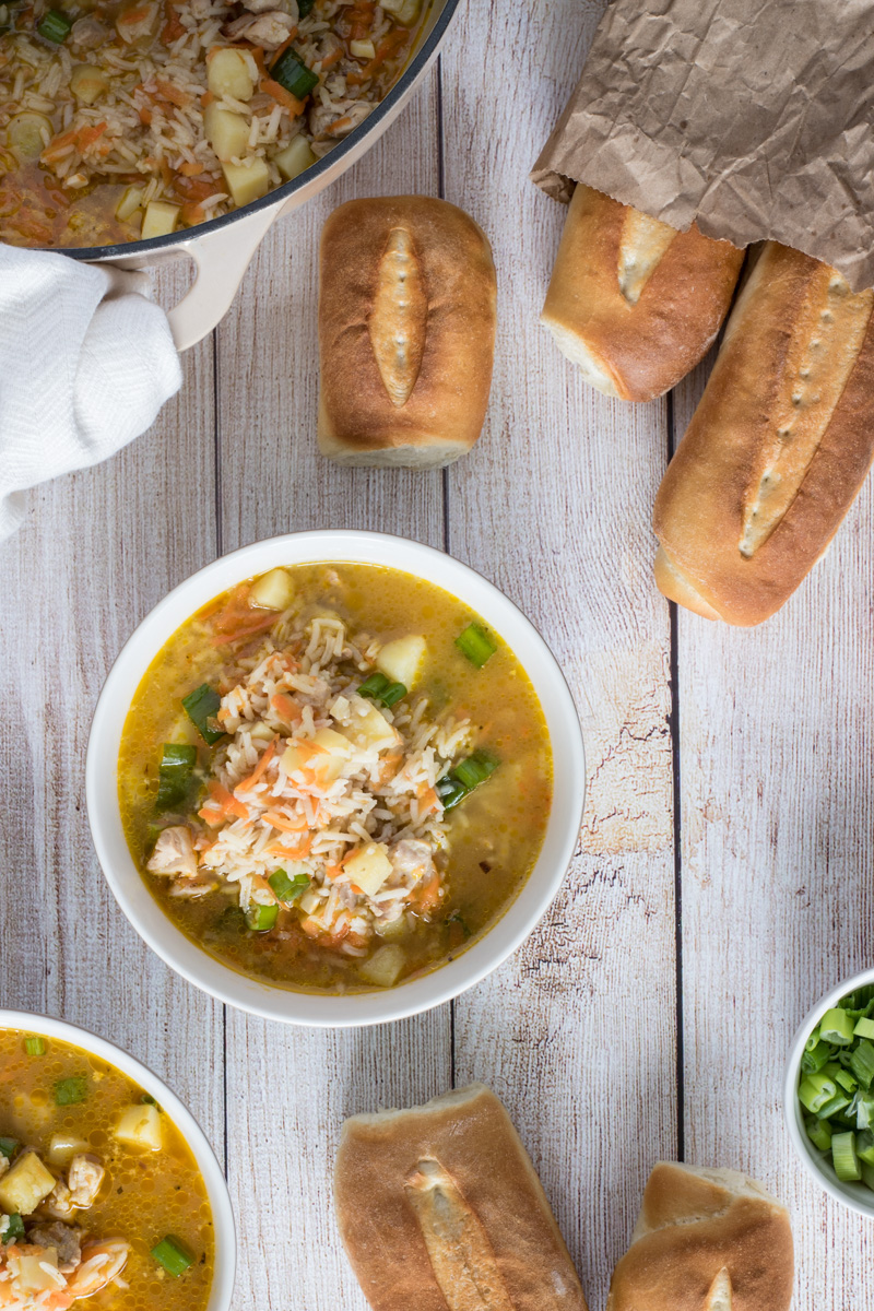 Bowls of chicken and rice soup and bread.