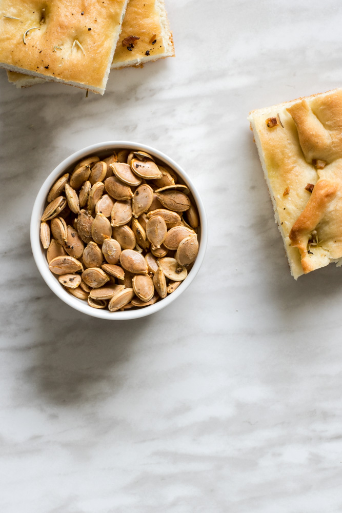 Roasted pumpkin seeds and pieces of rosemary bread.