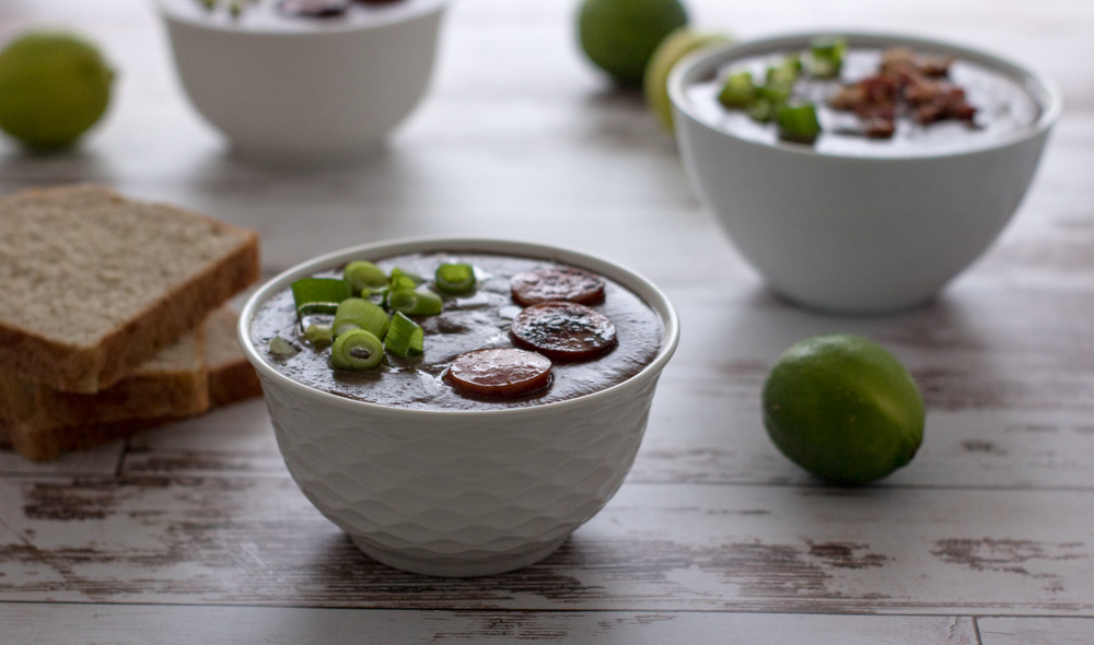 Bowls of soup with lime, bread.