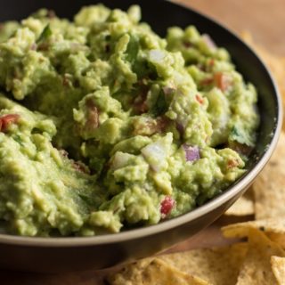 Easy guacamole close up, with tortillas arround the bowl.