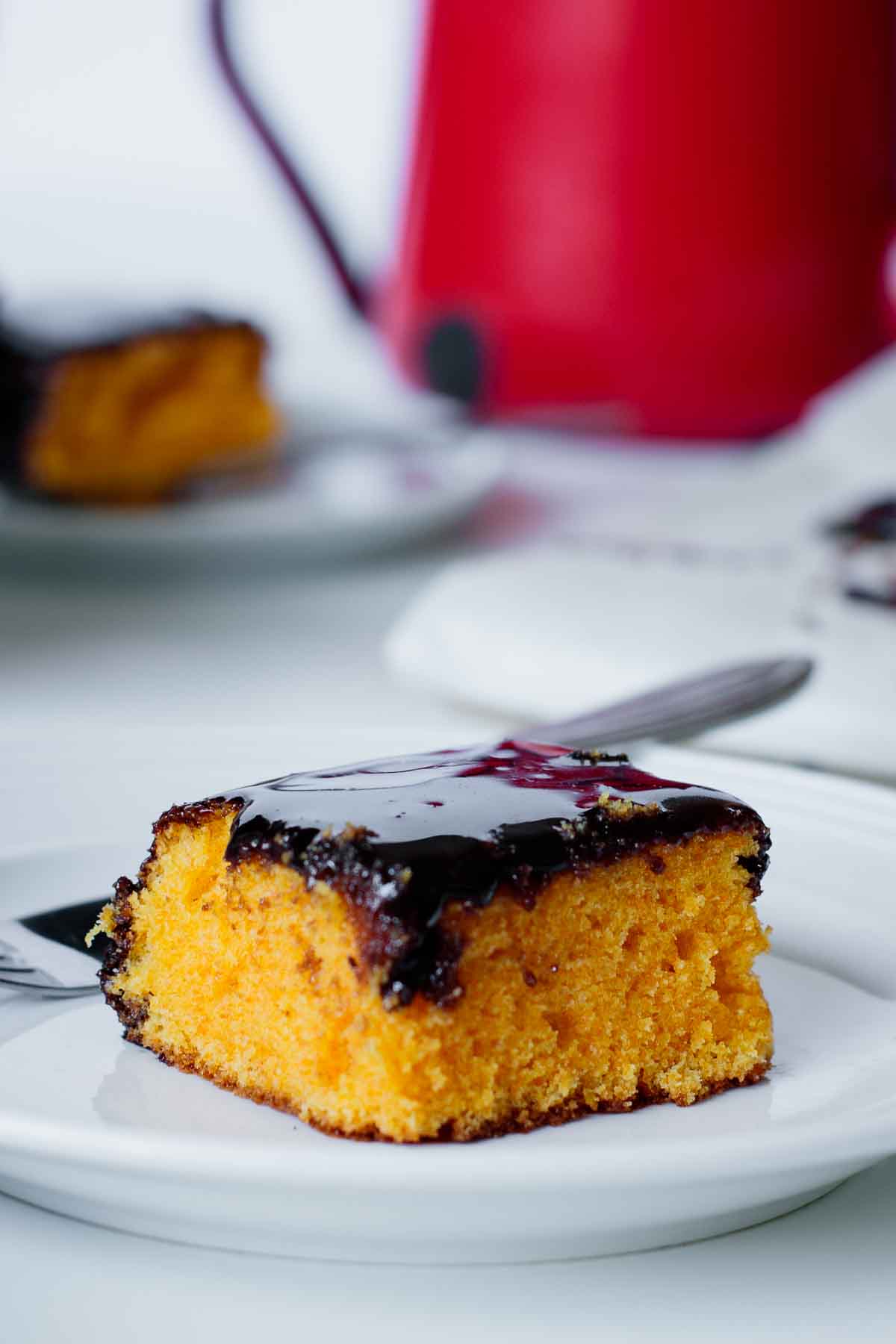 A piece of brazilian carrot cake with shiny chocolate glaze.