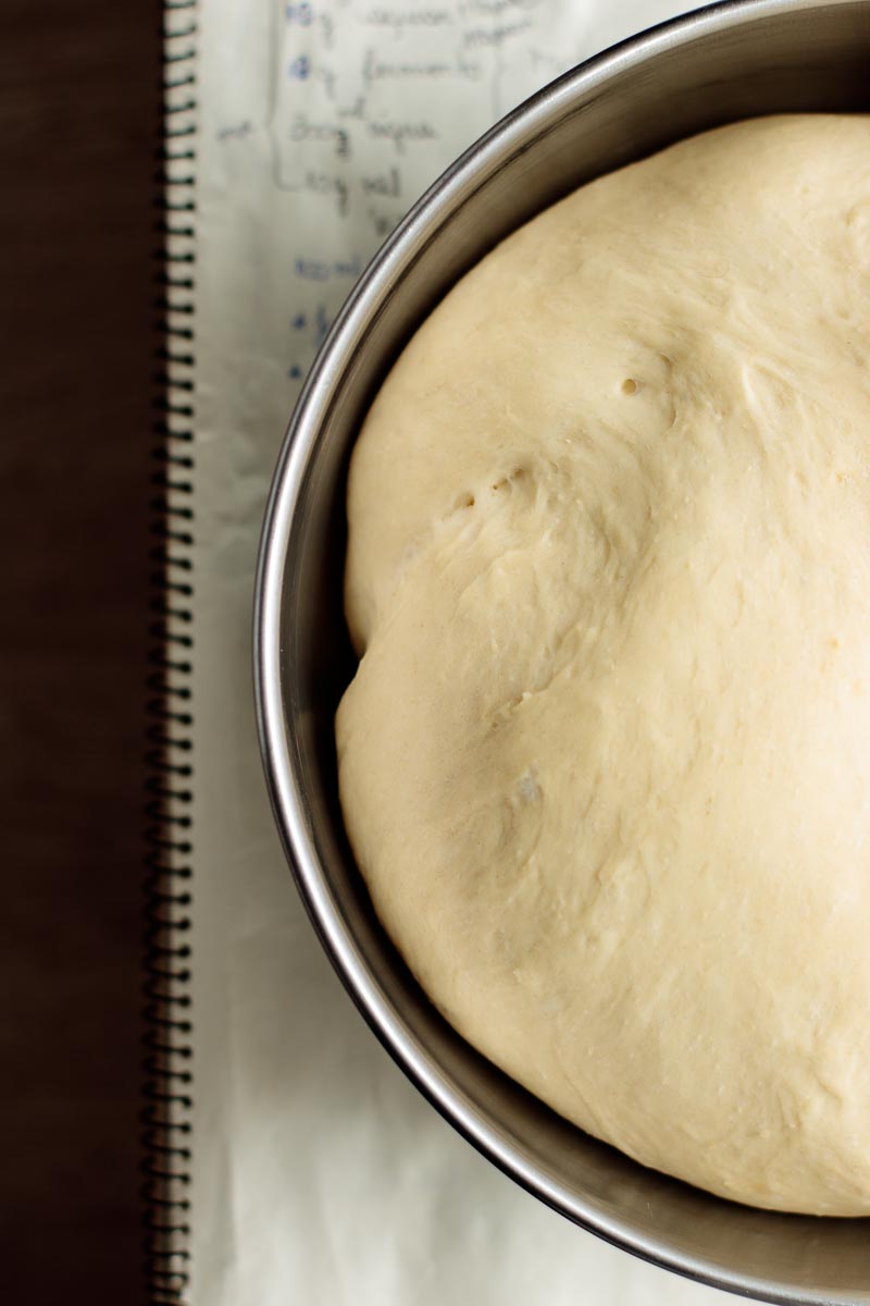 Dough rising in a large metal bowl.