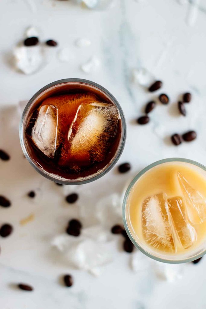 two cups of cold brew, one with it pure, one with it mixed with ice, seen from above