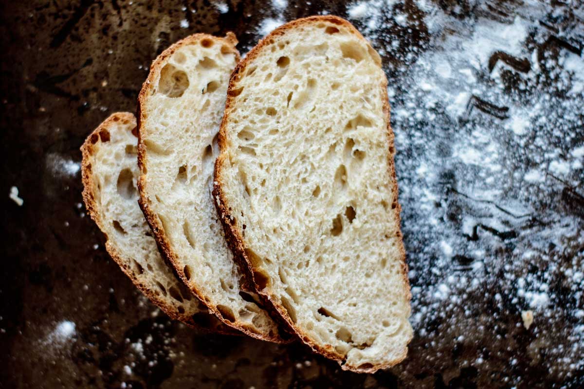 sliced of sourdough over a baking sheet with flour