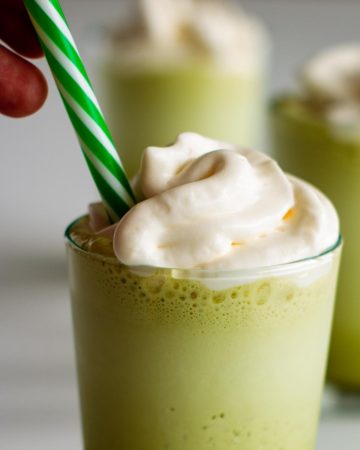 Starbucks Matcha Green Tea Frappuccino with green reusable straw and whipped cream