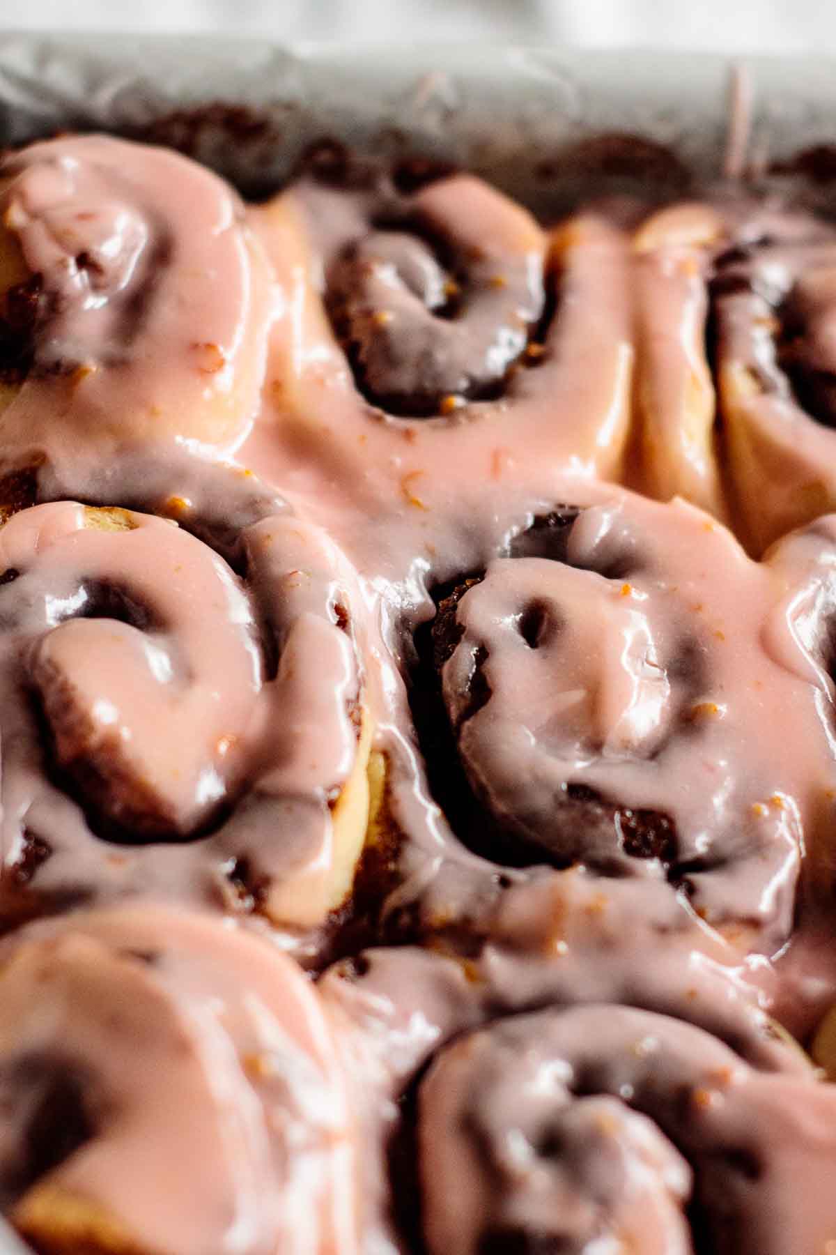 Blood orange cinnamon rolls on a baking pan.