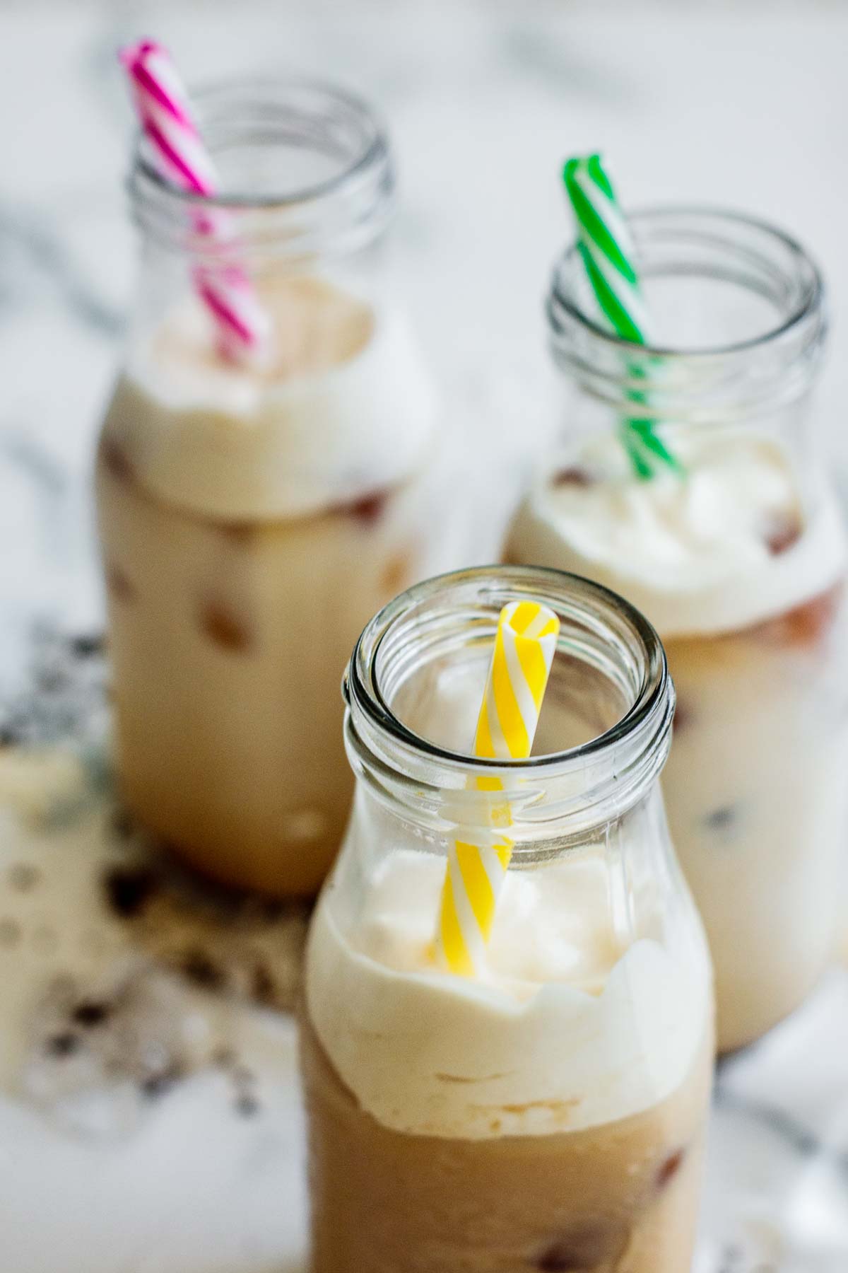 3 glasses of brown sugar milk tea with frothed cream and reusable straws