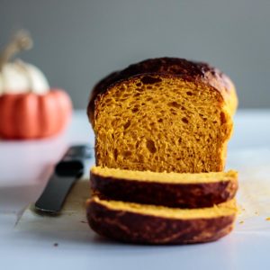 sliced pumpkin bread with pumpkins on the background