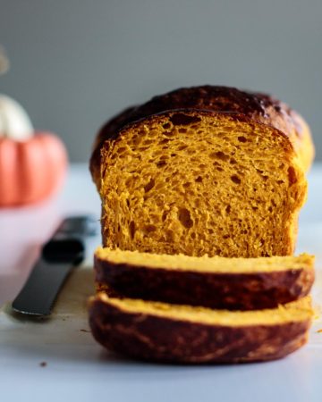 sliced pumpkin bread with pumpkins on the background