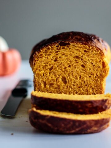 sliced pumpkin bread with pumpkins on the background