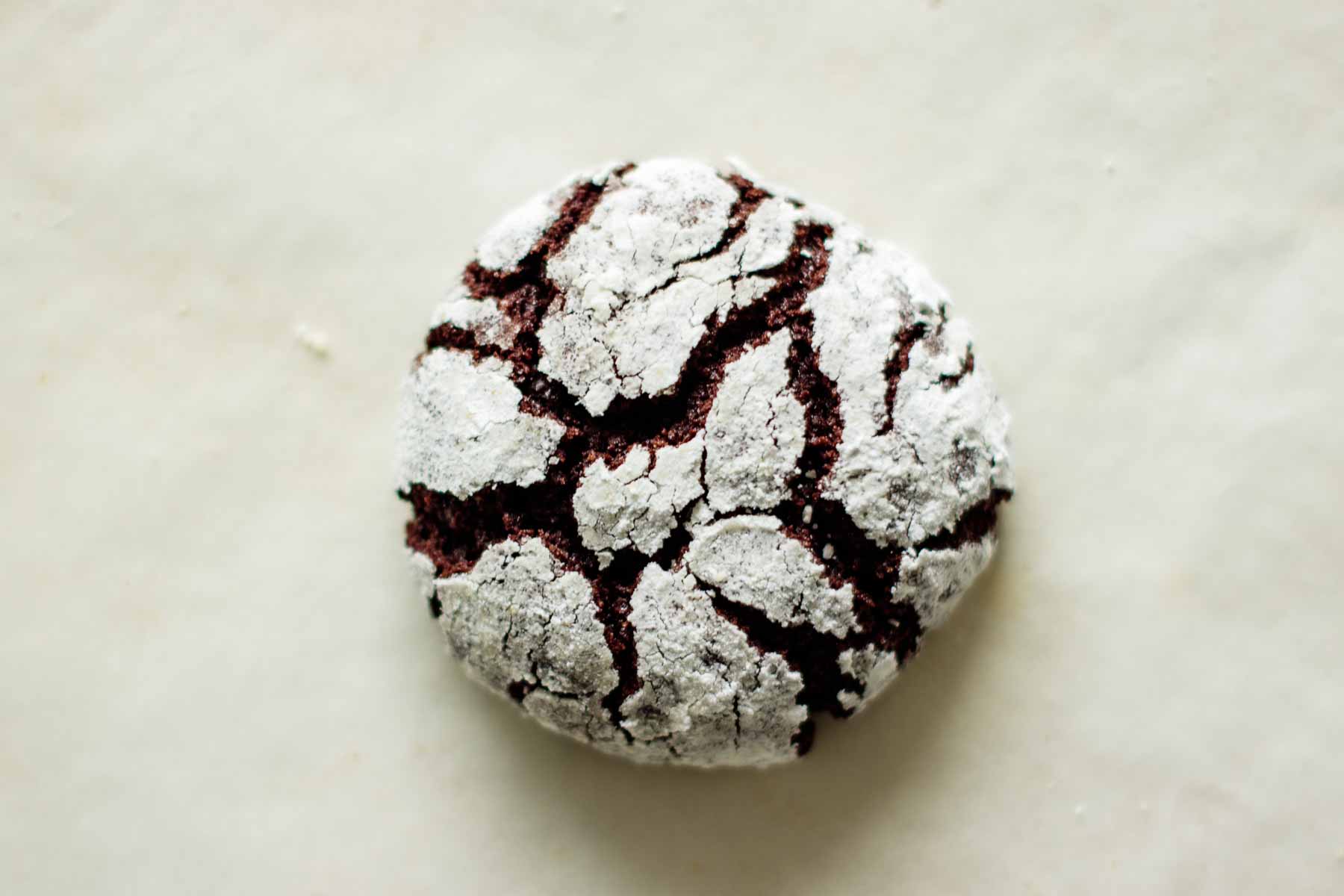a single chocolate crinkle cookie with white background