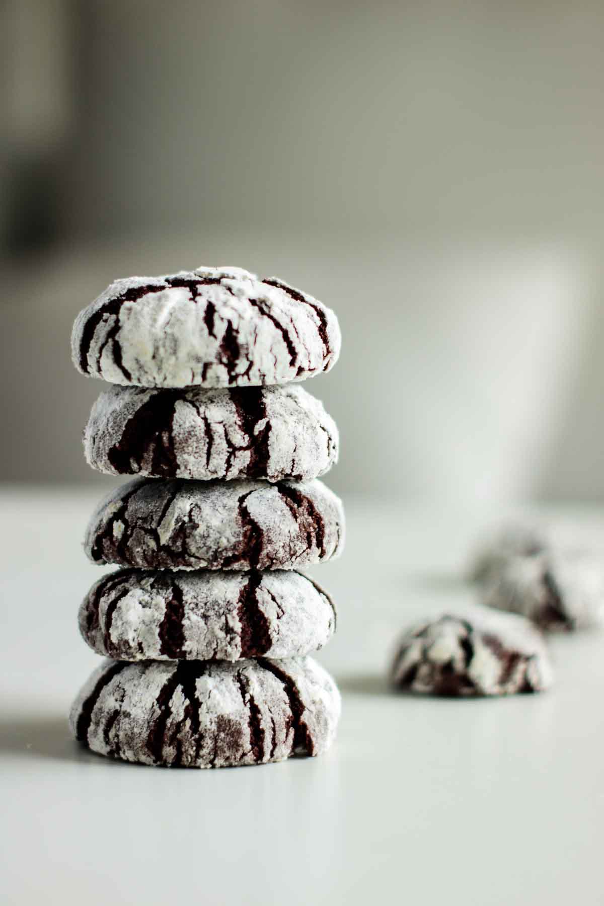 a stack of chocolate cookies, with more cookies on the background