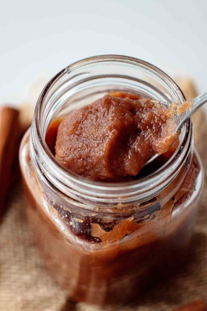 deep caramel color instant pot apple butter being spooned