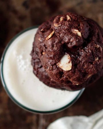 double chocolate almond cookie on top of a glass milk
