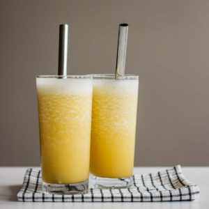 closeup of 2 glasses of hangover smoothie over white and blue kitchen towel