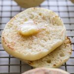 Sourdough english muffin with butter, sliced open.