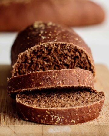 a sliced outback bread roll showing its crumb, over a wooden board