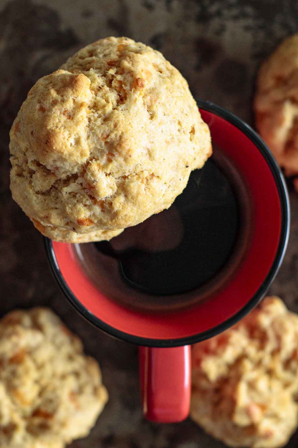 A biscuit over a red coffee mug.