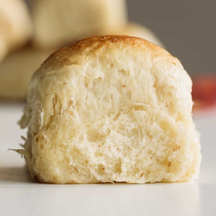 Close up on sourdough dinner roll, showing its soft crumb.