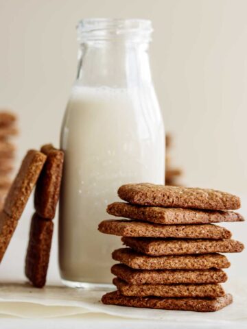 A stack of vegan graham crackers and a bottle of oat milk.
