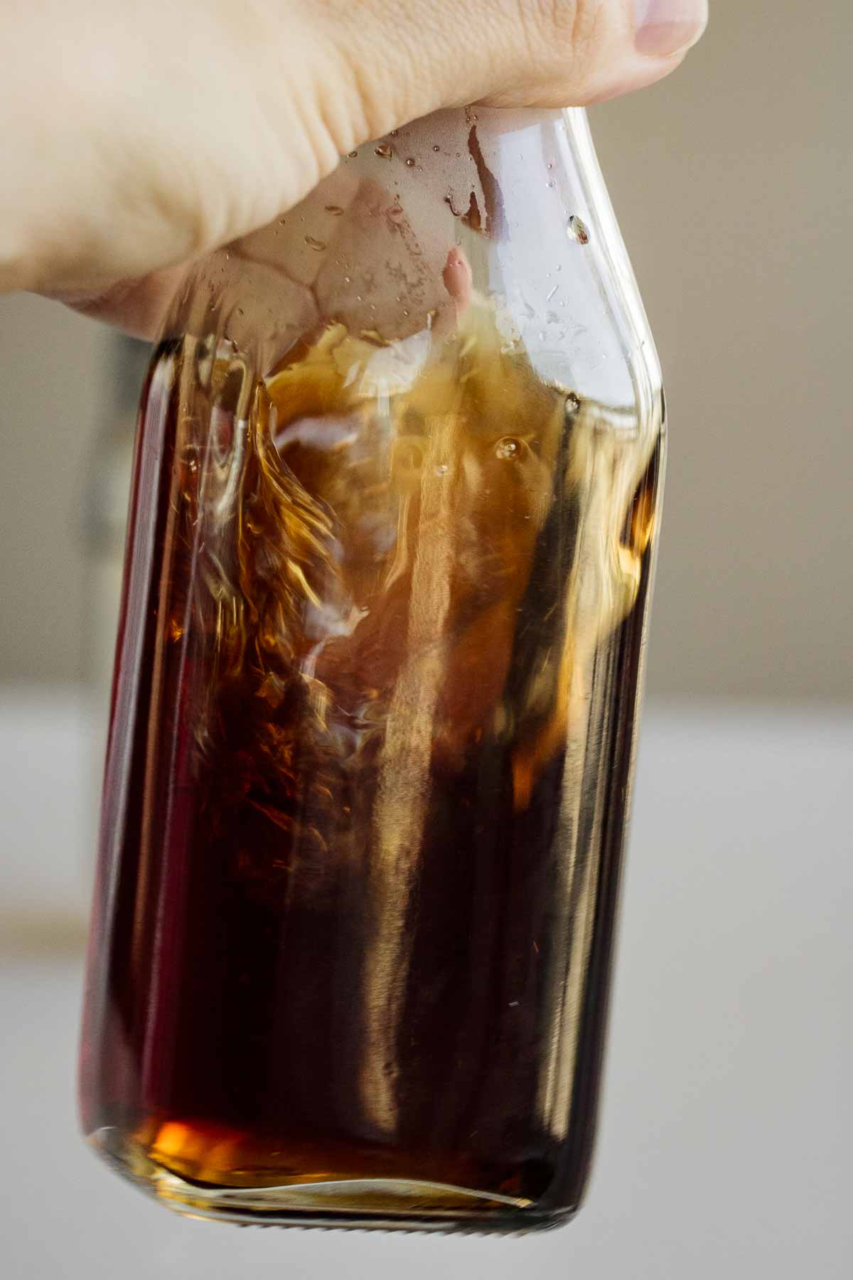 Brown sugar syrup swirling in a glass jar.