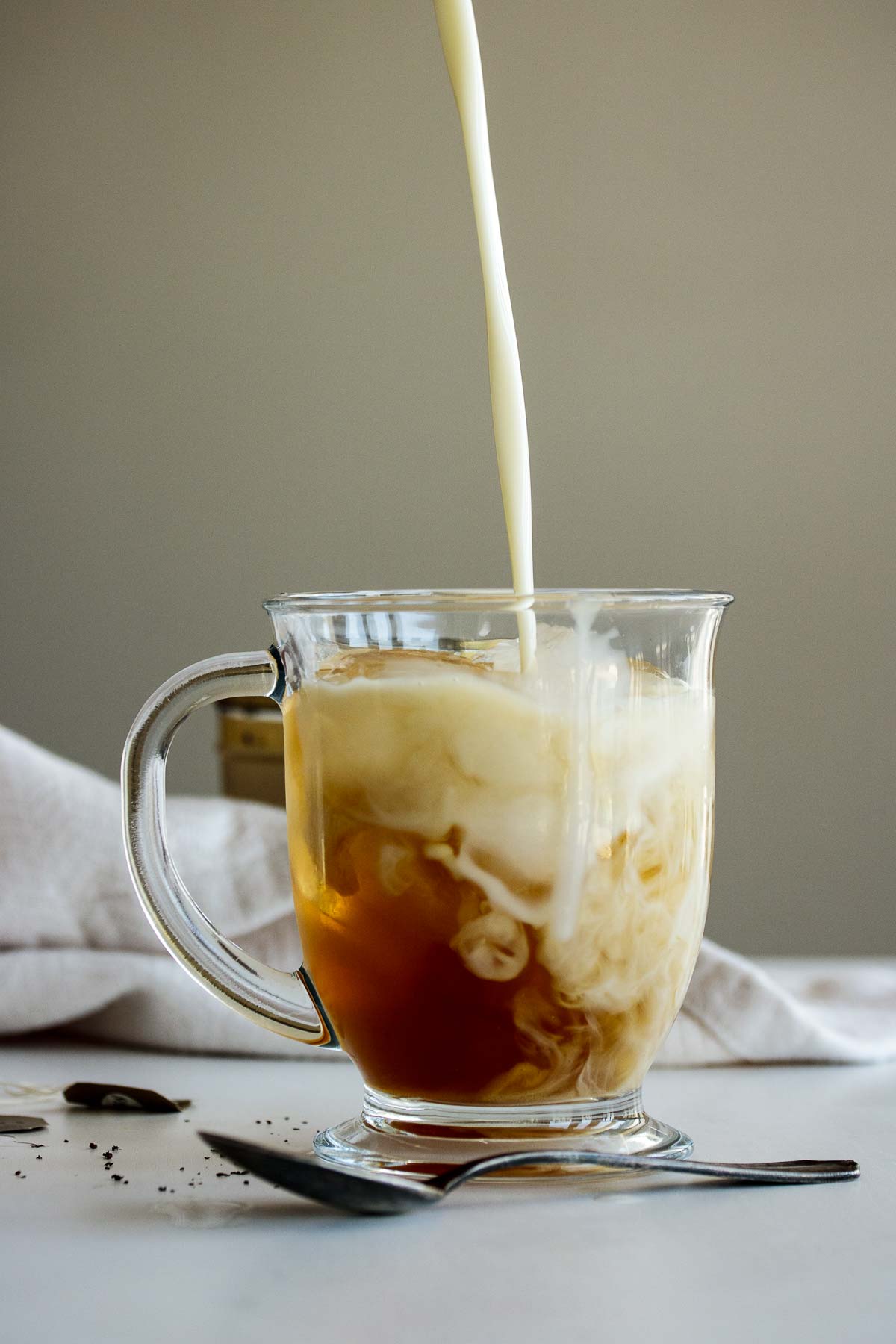 Milk pouring into cold brew earl grey.