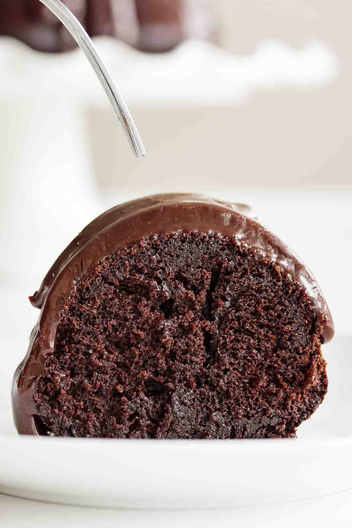 A fork over a slice of sourdough chocolate cake.
