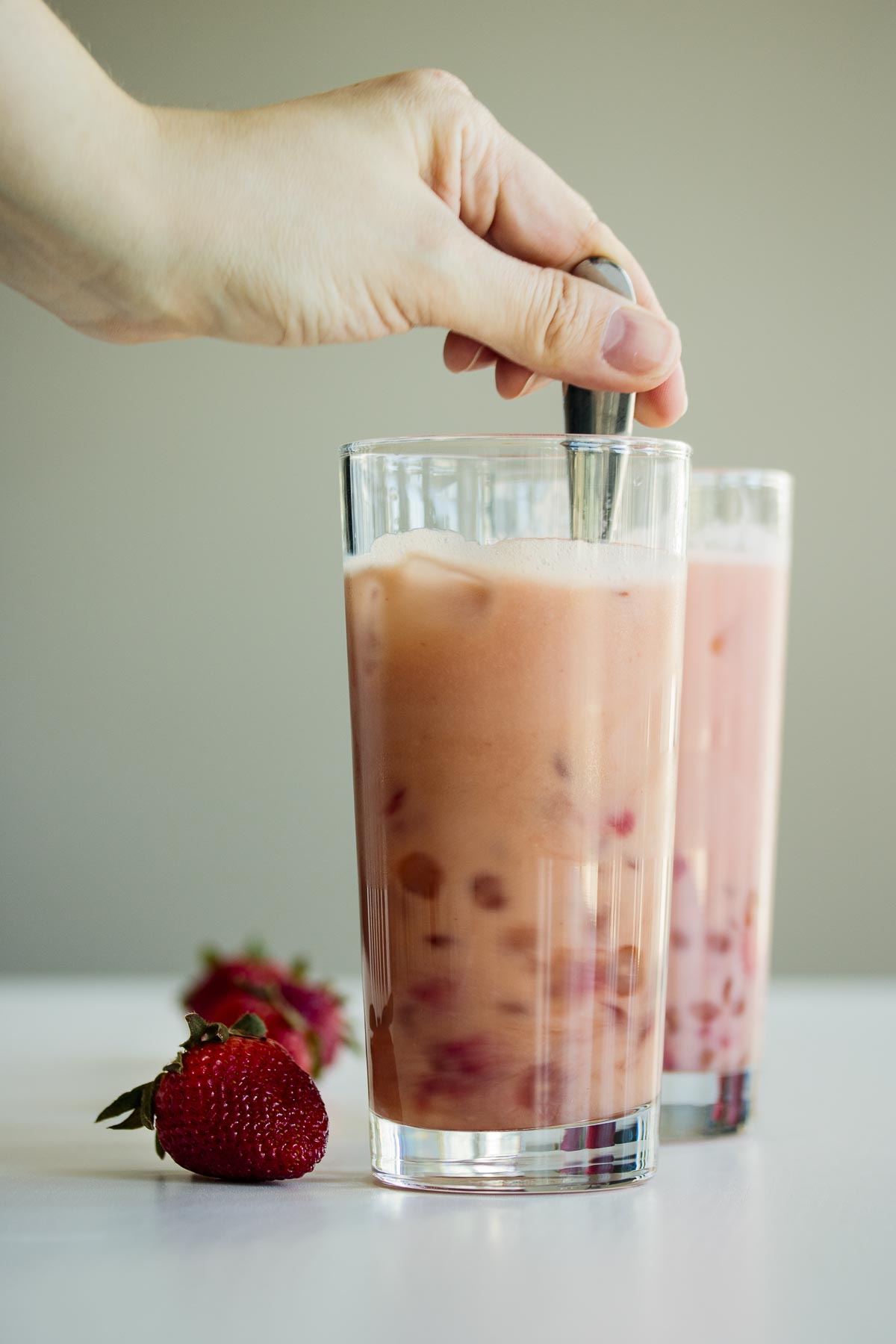 Hand stirring beverage.