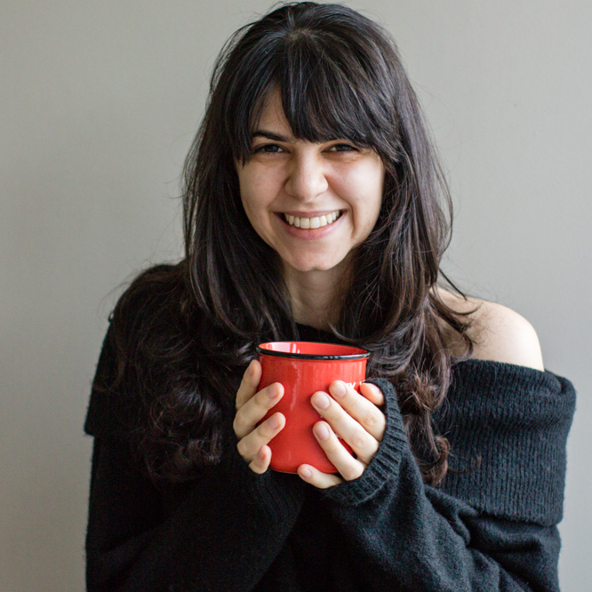 Tatiana holding a red mug.