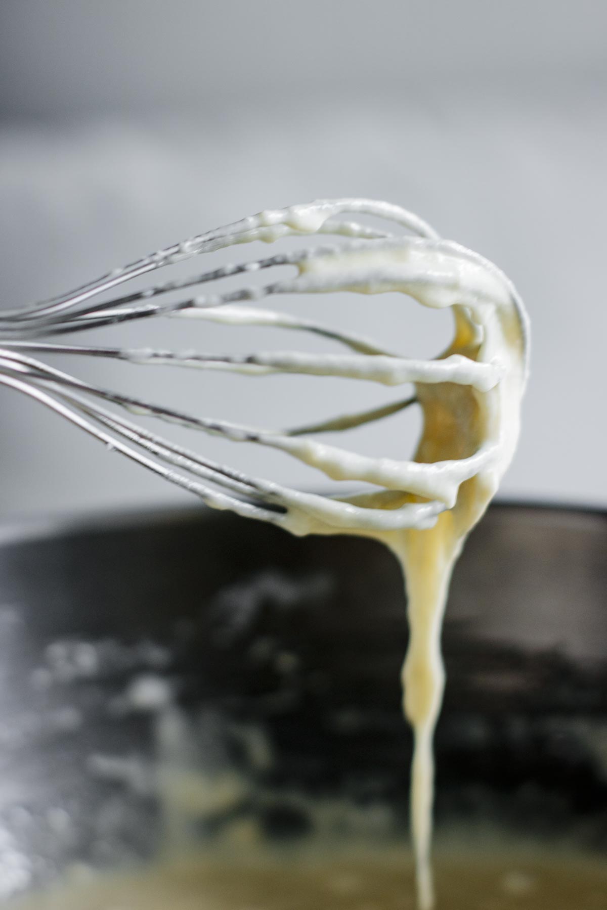 Batter pouring out of a whisk.