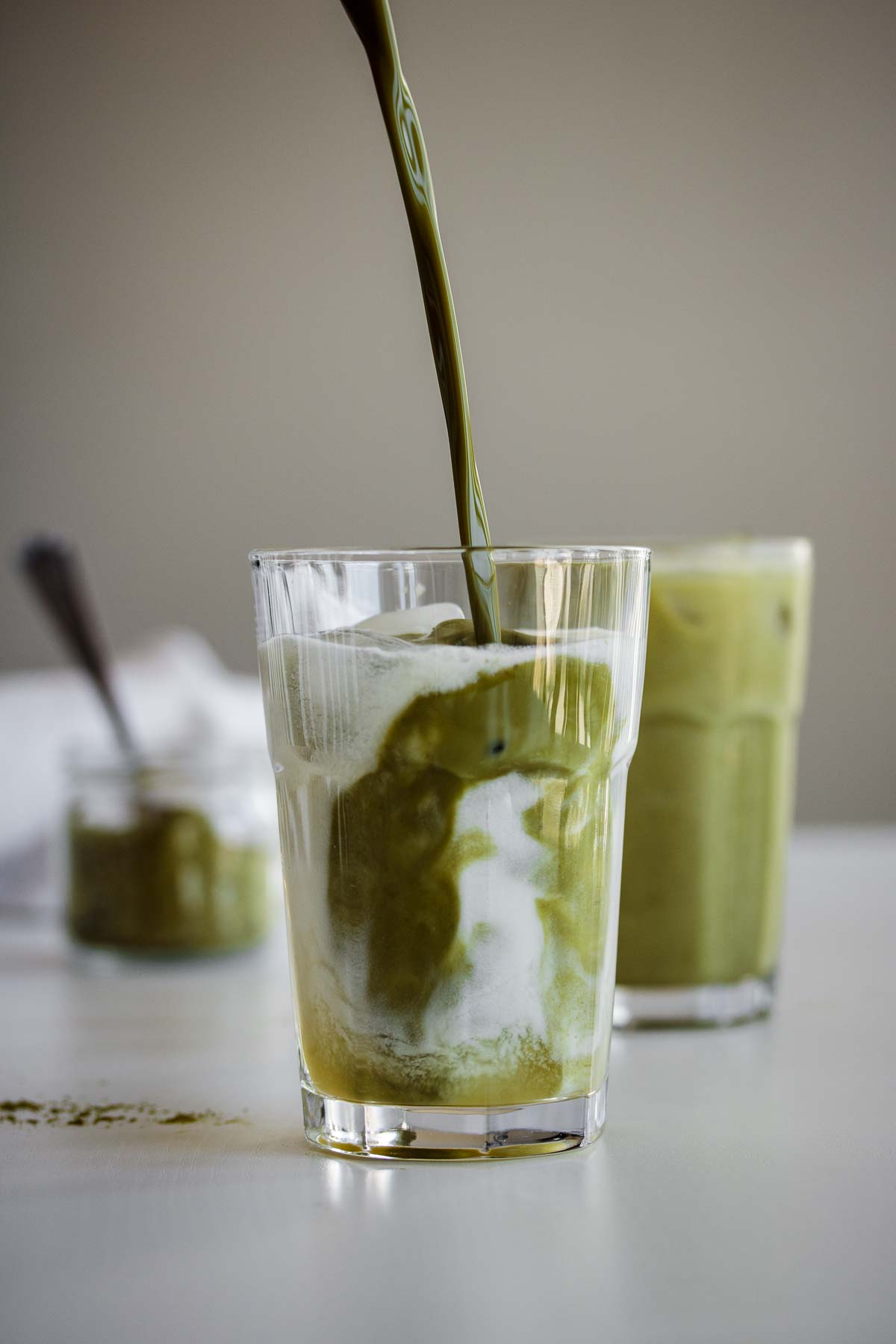 Matcha pouring into coconut milk.