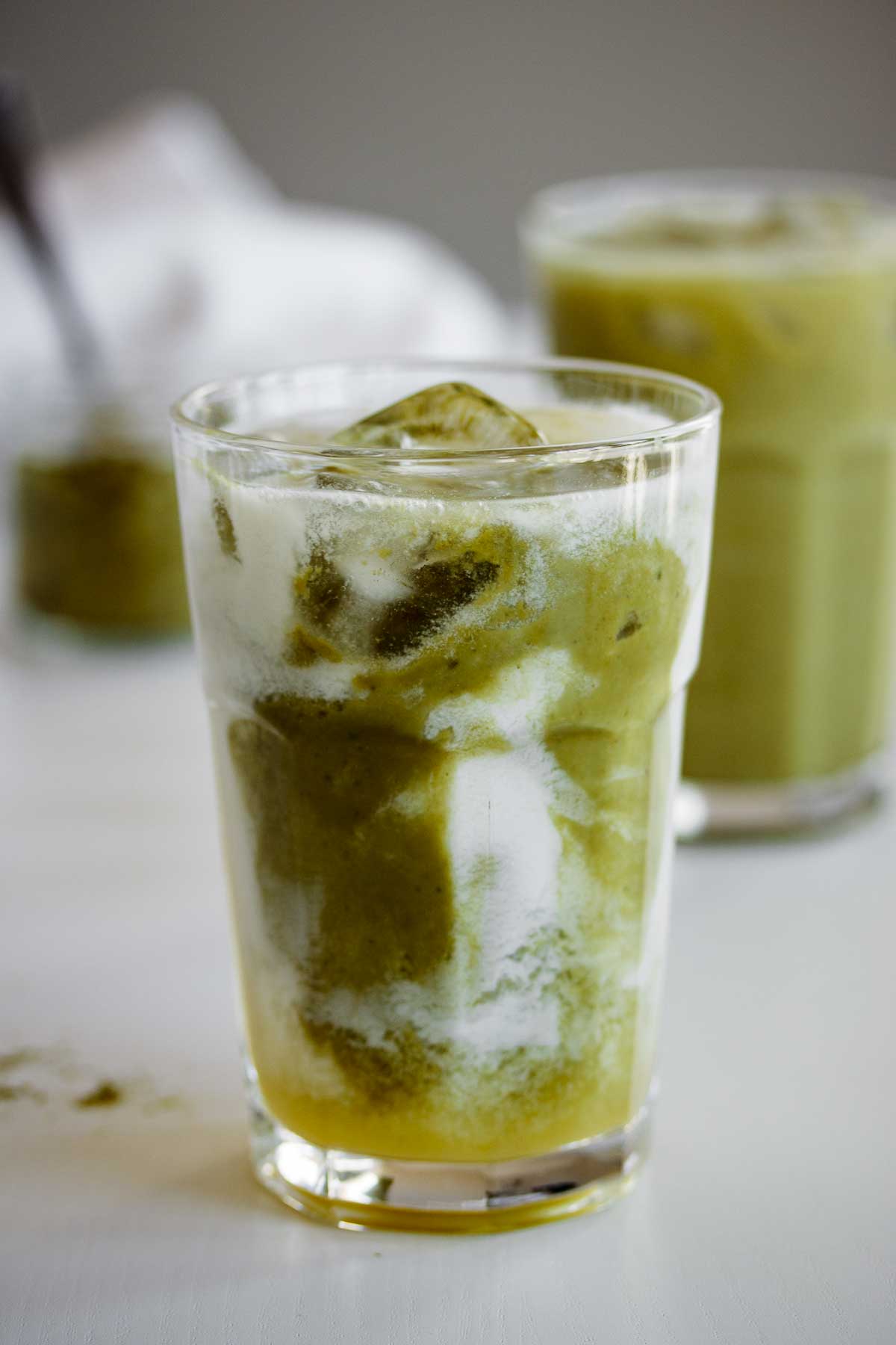 A glass of this drink, with green and white layers.