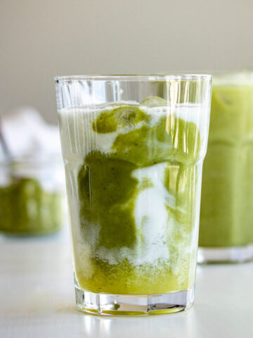 Two glasses of iced pineapple matcha drink.