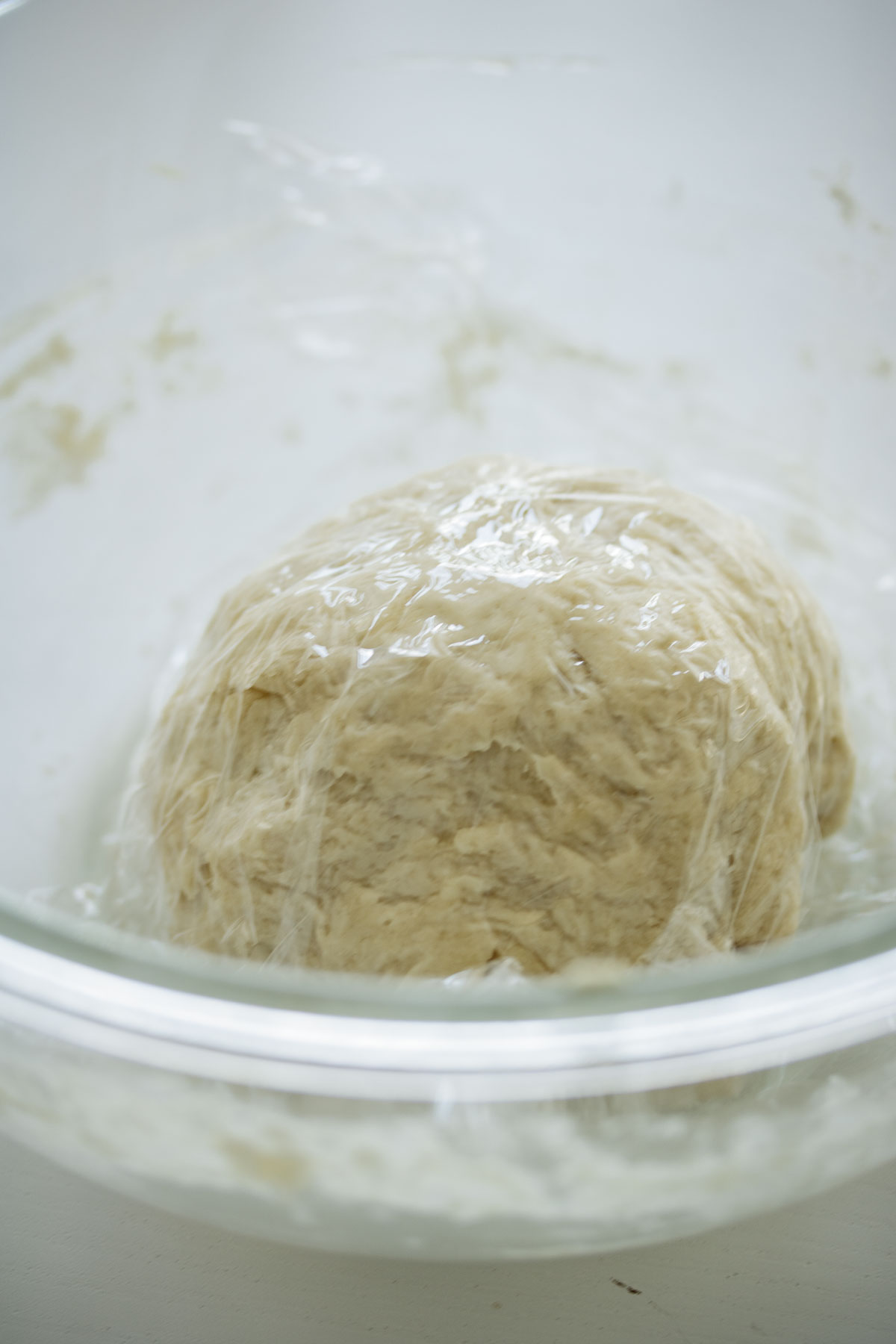 Dough covered, resting inside a glass bowl.
