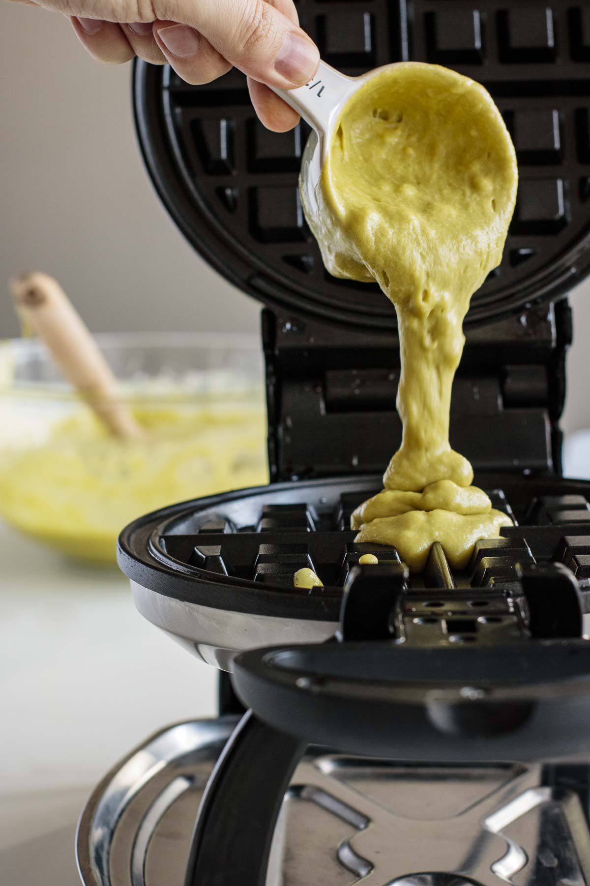 Batter being poured in preheated waffle iron.