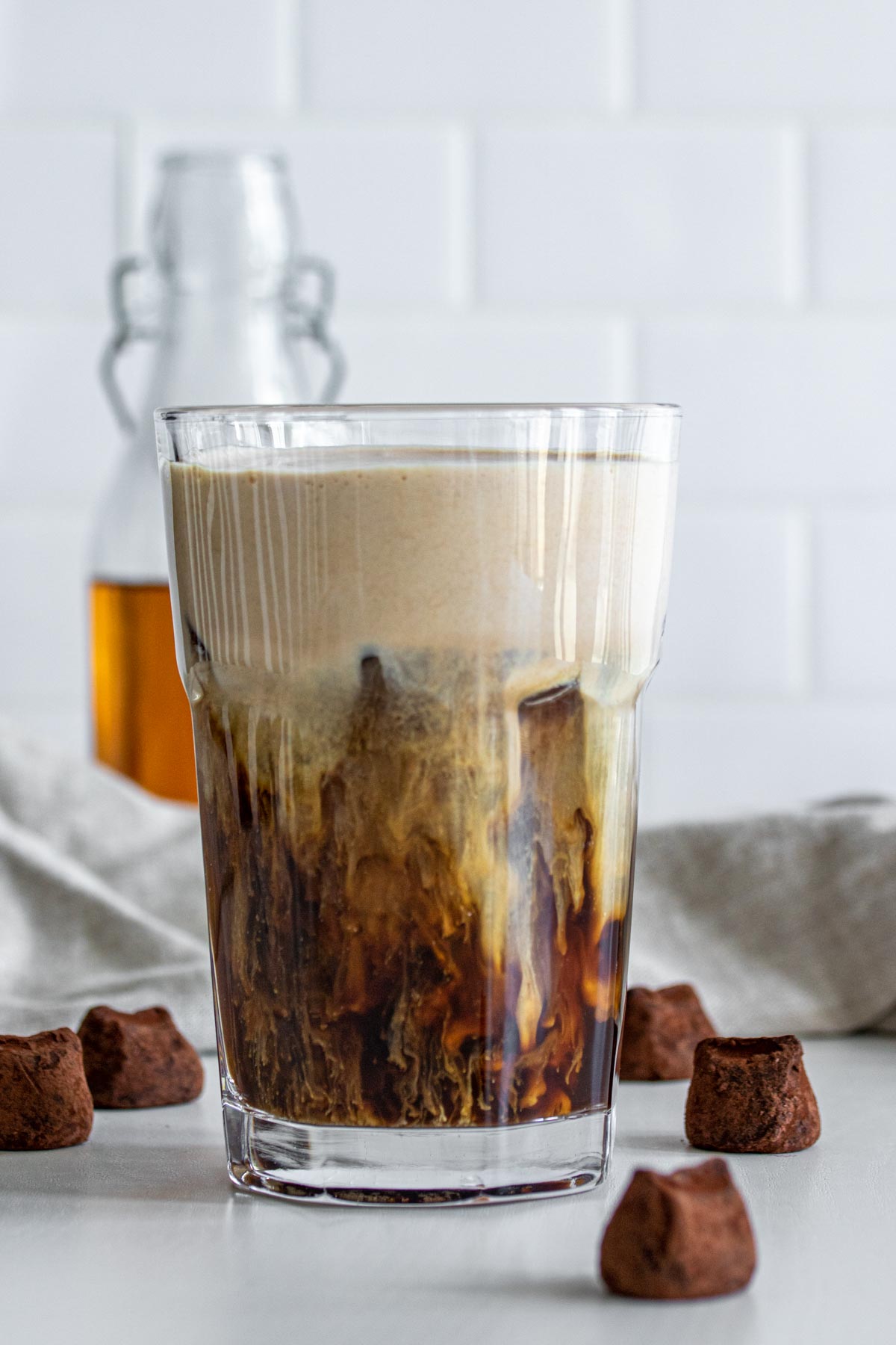 Chocolate Coffee Beverage in a glass, with chocolate truffles around.