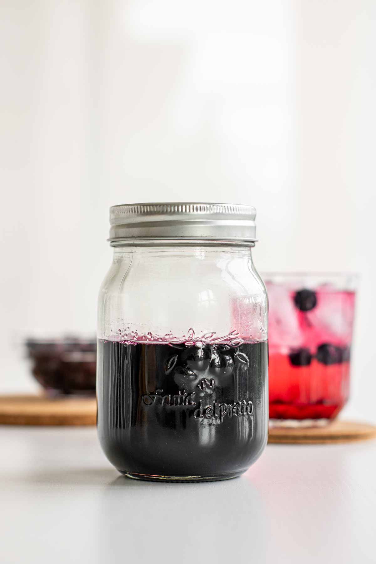 A jar of purple blueberry sugar syrup.