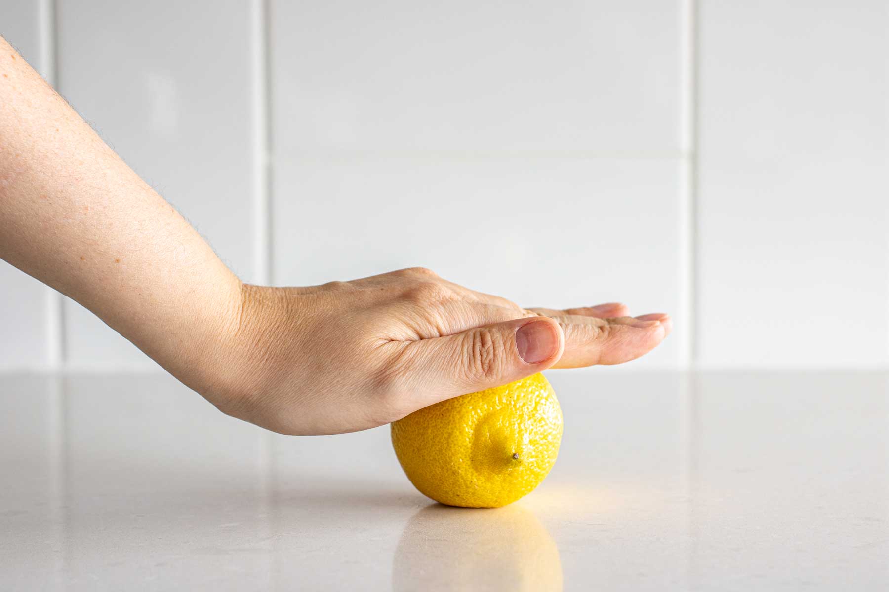 Hand rolling a lemon.