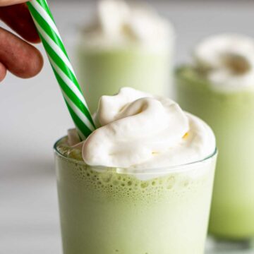 A matcha frappuccino topped with whipped cream.