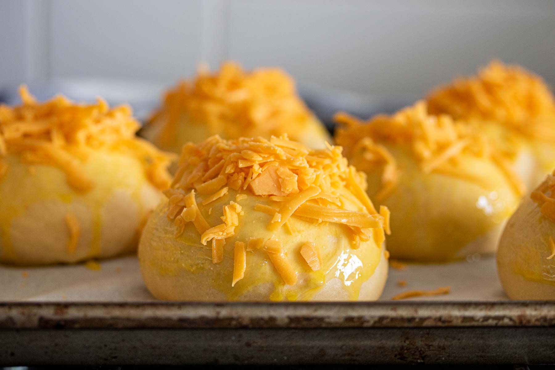 Buns covered with cheddar cheese.