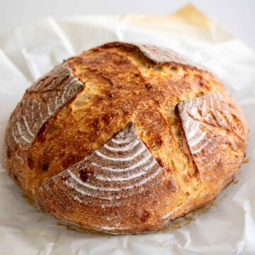 Sourdough parmesan bread over parchment paper.