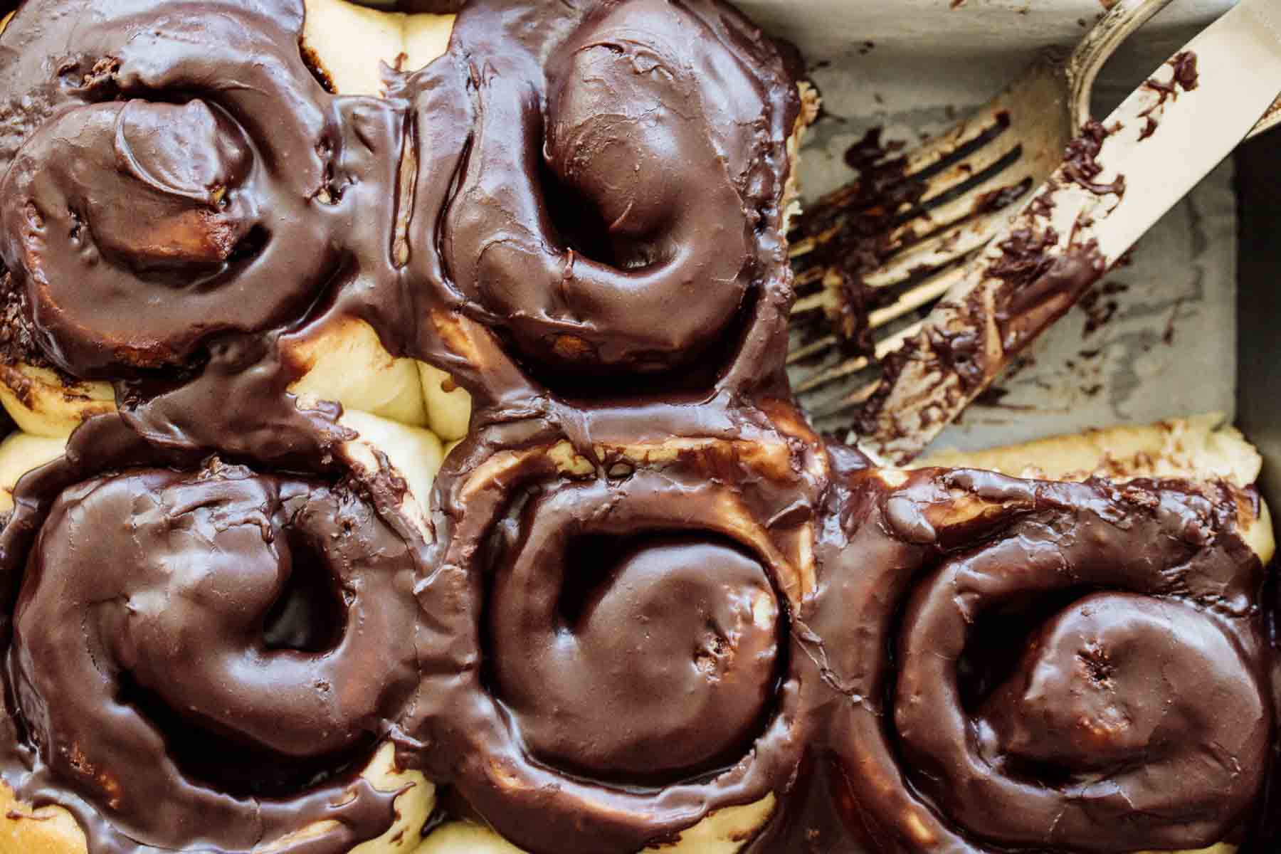 A baking pan full of Nutella rolls with cutlery.