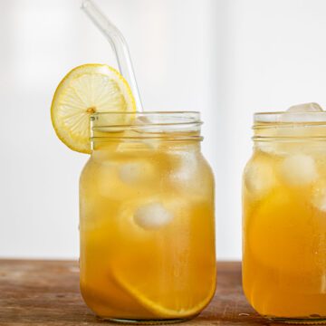 Two glasses of Earl Grey Lemonade, with lemon slice and glass straw.