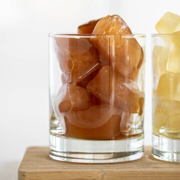 Black and herbal tea ice cubes inside glass.