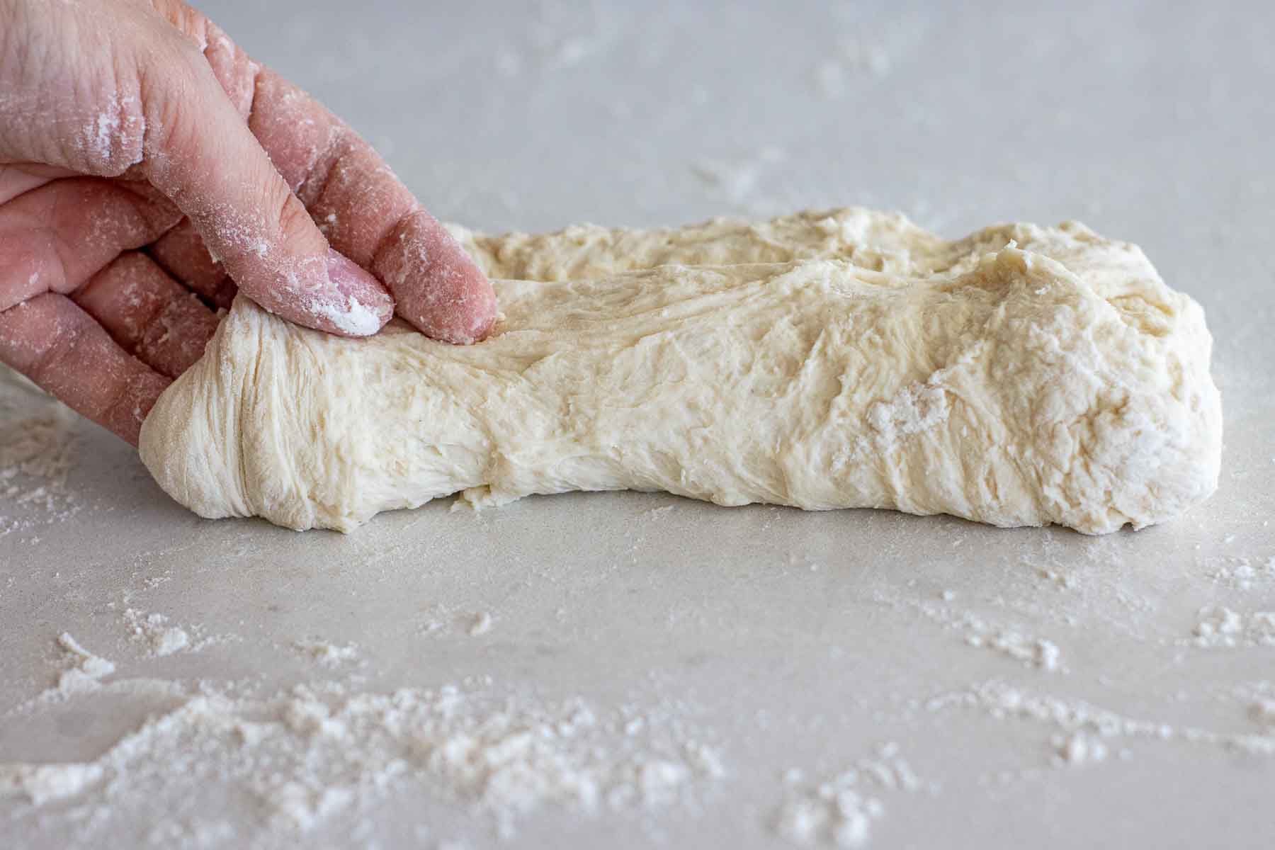 Folding the other half of the baguette dough.