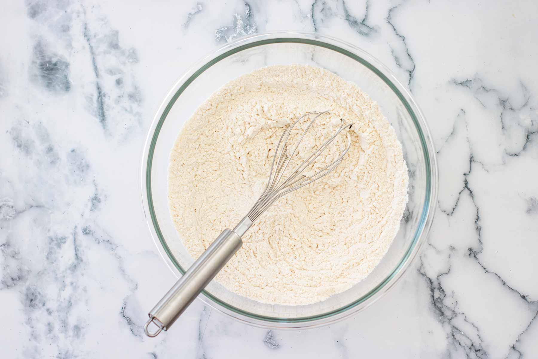 Mixing the dry ingredients in a bowl with a whisk.