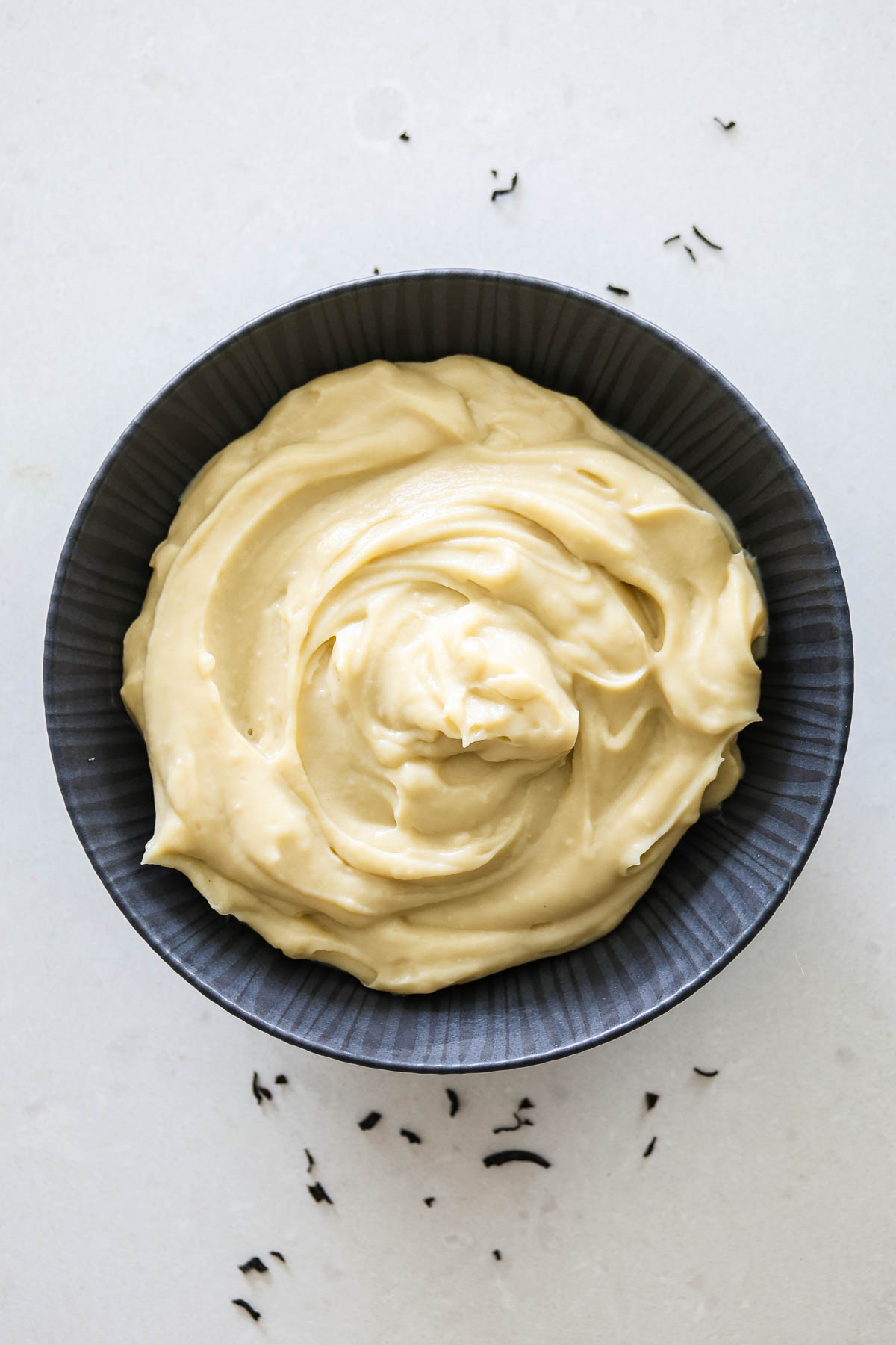 Earl Grey custard in a black bowl.