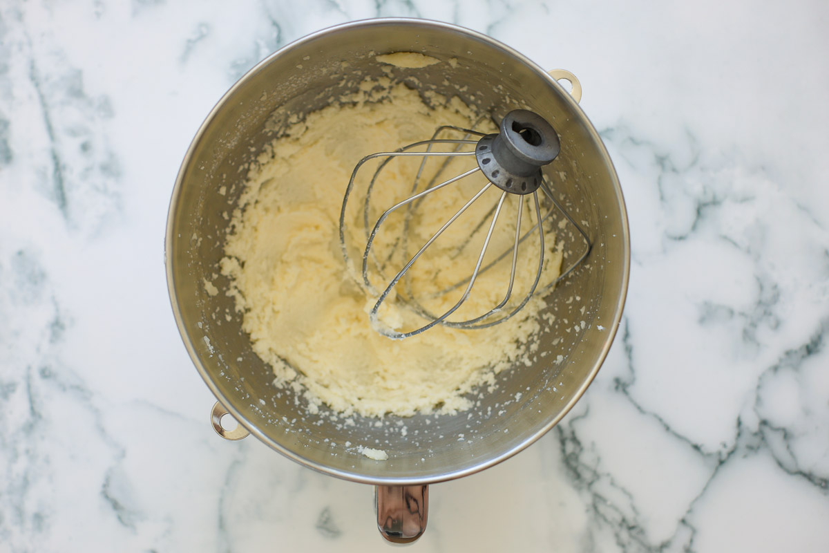 Creamed butter, metal bowl, with stand mixer whisk attachment.