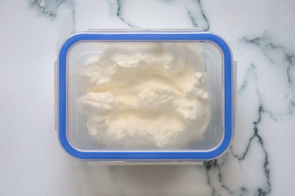 Whipped cream inside an airtight container with lid.