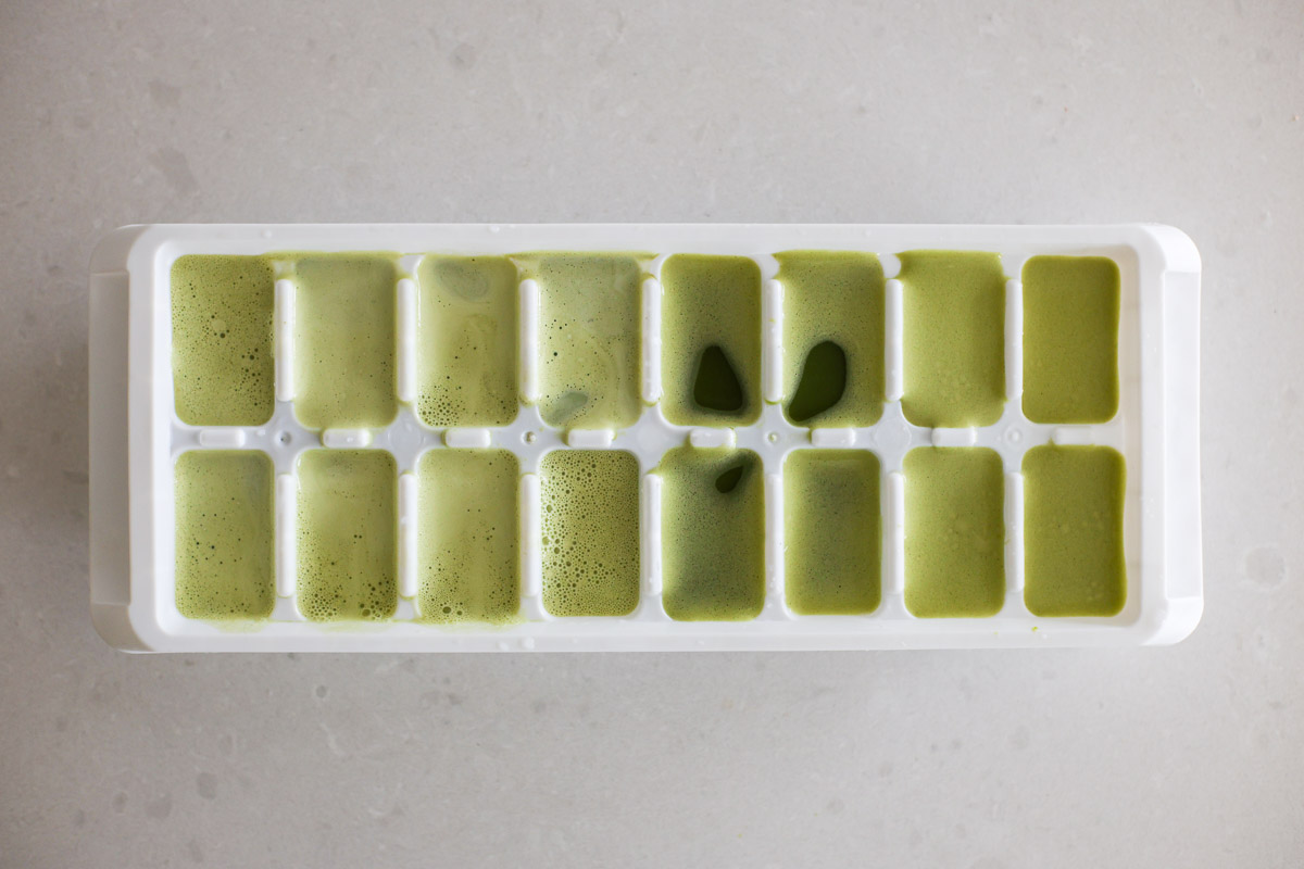 Matcha ice cubes on ice tray before freezing.